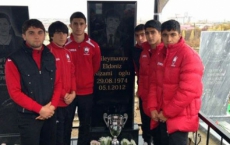 Academy players hitting their trophy in honor of their late skipper